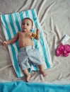 Excuse me while I get my beach on. Concept shot of an adorable baby boy lying on a towel at a make believe beach. Royalty Free Stock Photo