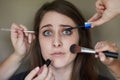 Beauty can be daunting. Concept shot of a nervous looking young woman with an assortment of brushes applying makeup to Royalty Free Stock Photo