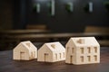 Concept shot: three differently sized wooden models of houses on an architects table