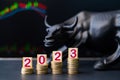 Concept showing of 2023 bullish stock market by placing coins in increasing order with running stock market charts