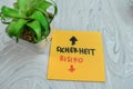 Concept of Sicherheit or Risiko write on sticky notes isolated on Wooden Table