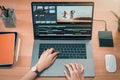 Concept of simple operation of blogger and vlogger, hand using laptop on video editor works with footage on wooden table. Royalty Free Stock Photo