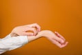 Concept skin allergy. Close up of woman scratches her hands on brown background with copy space.