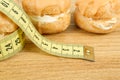 Concept of slimming, closeup of caramel cakes with measuring tape