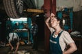 The concept of small business, feminism and women`s equality. A young female auto mechanic wearily wipes sweat from her forehead Royalty Free Stock Photo