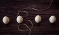 The concept is small chocolate eggs and a thread. On a wooden background