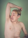 Guy sniffs his armpits Royalty Free Stock Photo