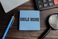 Concept of smile more write on sticky notes isolated on Wooden Table Royalty Free Stock Photo
