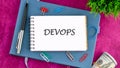 Concept for software engineering culture and practice of software development. DEVOPS word in a mini notebook on a