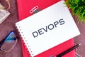 Concept for software engineering culture and practice of software development. DEVOPS word in a mini notebook on a
