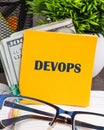 Concept for software engineering culture and practice of software development. DEVOPS word written on a yellow sticker