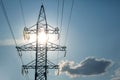 The concept of a source of electricity. Energy industry. High voltage tower with power wires against the background of the sun and Royalty Free Stock Photo