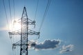 The concept of a source of electricity. Energy industry. High voltage tower with power wires against the background of the sun and Royalty Free Stock Photo