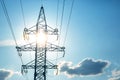 The concept of a source of electricity. Energy industry. High voltage tower with power wires against the background of the sun and Royalty Free Stock Photo