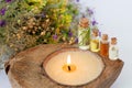 Concept of SPA procedure with herbal essential oils, burning candle and healthy wildflowers