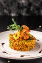 Concept of Spanish cuisine. Paella with seafood, shrimps, squid and greens. Beautiful serving in restaurant