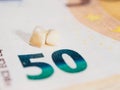 Concept of spending money to the dentist. Two calf's teeth lie on the fifty euro banknote. Selective focus. Copy space.