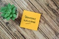 Concept of Sponsors Welcome write on sticky notes isolated on Wooden Table