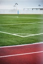 Concept: Sport. Detail of the corner of the soccer field next to the athletics track