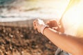 The concept of sport. Female hands with a wristwatch close-up. In the background, the coast and the sea. Copy space