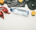 Concept of sports lifestyle, headphones, dumbbells, oranges, a bottle of water, a t-shirt for training place for text flat lay Royalty Free Stock Photo