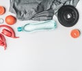 Concept of sports lifestyle, headphones, dumbbells, oranges, a bottle of water, a t-shirt for training place for text flat lay Royalty Free Stock Photo