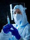 Detail closeup of syringe needle and ampoule , nurse taking injection shot,hands in blue protective gloves holding