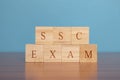 Concept of SSC exam conducted in India, in wooden block letters on table