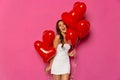 Smiling girl with balloons in two hands celebrating Valentine`s day. Royalty Free Stock Photo