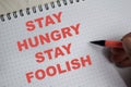 Concept of stay hungry stay foolish write on book isolated on Wooden Table Royalty Free Stock Photo