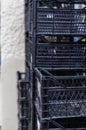 Used food boxes. Piles of black plastic boxes for fruits and vegetables.