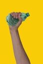 Concept of stop plastic pollution, global warming, recycling plastic, plastic free. Man`s hand tightly squeezes an empty green