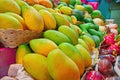 Concept street trade exotic fruits. Tropical fruits on counter of a street shop. Ripe yellow mango and dragon fruit. Royalty Free Stock Photo