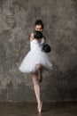 Strong and feminine woman - ballerina fighting in white costume and boxing gloves