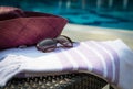 Concept of summer accessories close-up of white and purple Turkish towel, sunglasses and straw hat. Royalty Free Stock Photo