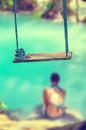 Concept of summer traveling with wooden swing and woman wearing