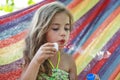 Concept summer, vacation, weekend- beautiful blond-haired girl with blue eyes is lying on a bright hammock with rainbow colors Royalty Free Stock Photo