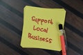 Concept of Support Local Business write on sticky notes isolated on Wooden Table