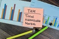 Concept of TAM - Total Addressable Market write on sticky notes isolated on Wooden Table Royalty Free Stock Photo