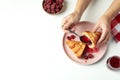 Concept of tasty eating with croissant with raspberry jam on white background