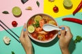 Concept of tasty eating with Tom yum soup on multicolor background