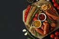 Concept of tasty food with tray of grilled sausage on black background