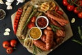 Concept of tasty food with tray of grilled sausage on black background