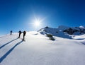 A group of skialpers work together to reach the summit of the mountain