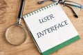 The concept of technology and development. Phrase, word, text USER INTERFACE in a notebook on an old background, in a