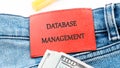 The concept of technology and development. Phrase, words, text DATABASE MANAGEMENT on the leather label of jeans Royalty Free Stock Photo