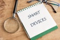The concept of technology and development. Phrase, words, text SMART DEVICES in a notebook on an old background, in a Royalty Free Stock Photo