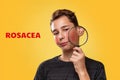 The concept of teenage acne. A teenage boy with a distressed face, holding a magnifying glass near his cheek with rosacea. Yellow