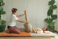 Concept thai Massage. Asian young woman getting thai herbal massage in spa salon.Thai girl stretching her legs with
