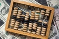 Concept on the theme of banking and finance. Closeup old wooden abacus lie on dollar bills.